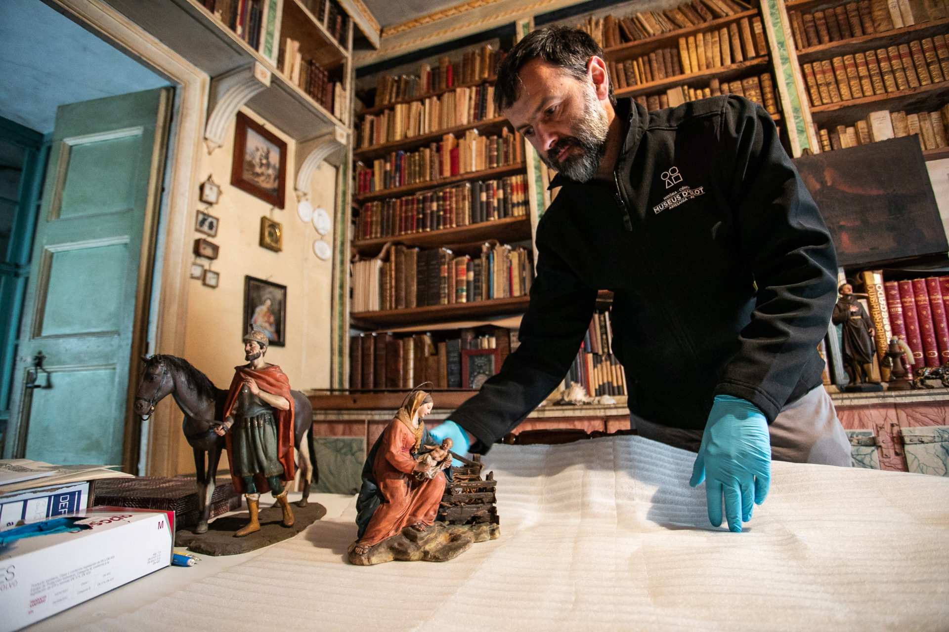 El tècnic dels Museus d'Olot Xevi Roura recollint les peces de Ramon Amadeu a Can Bolós. Foto: Martí Albesa.